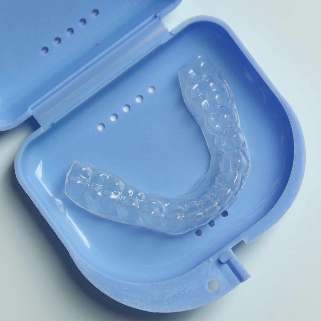 Burckhard Orthodontic photo of Clear Essix retainer in a blue case